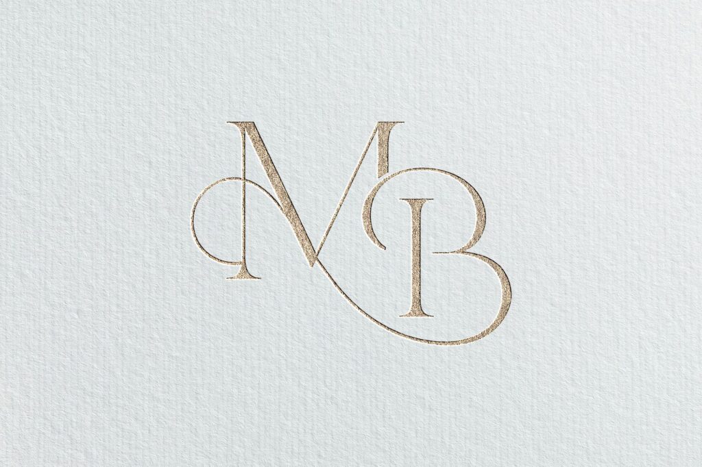 Elegant signature wedding monogram in gold on textured white paper